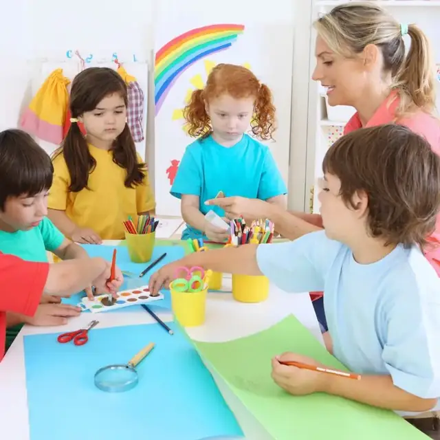 Preschool children drawing and crafting with an educator at a colourful art table at Beehouse Sunset St. in Burnaby