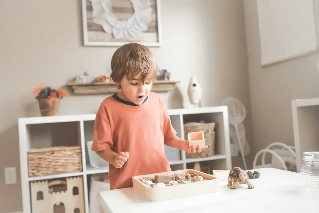 Child exploring Montessori materials on a table in a calm, bright classroom