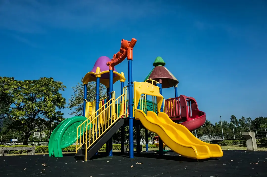 Colourful children's playground with slides under a clear blue sky